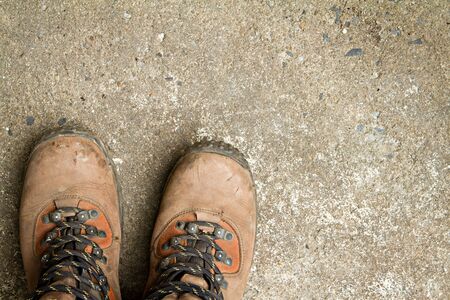 Dirty hiking boots, on concrete floor.