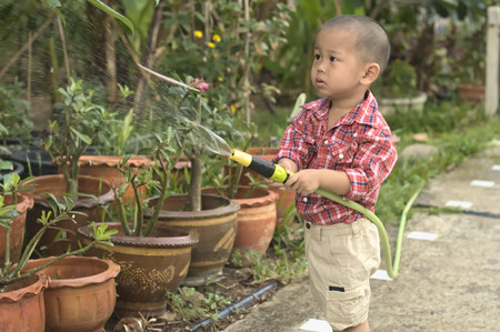 Half portrait of toddler watering flowersの写真素材