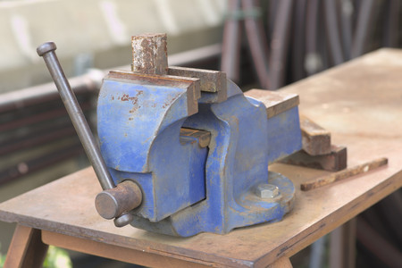 Bench vise station on rusty metal bench at construction siteの写真素材