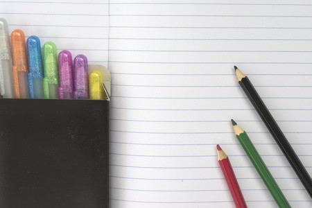 Notebook with colorful pen and pencils