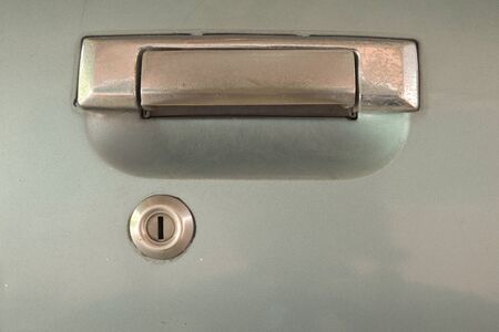 Old used car silver door handle with silver key hole blue door