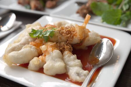 Deep fried fish with spicy sauce serve in white dishの写真素材