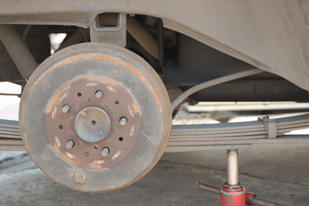 Abstract closeup of rusty drum brake of truck with wheel removal on top of jackの写真素材