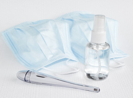 Protecting health from bacteria and viruses. Hand sanitizer, face mask and body thermometer.の写真素材