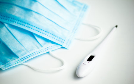 Protecting health from bacteria and viruses. Face mask and body thermometer.