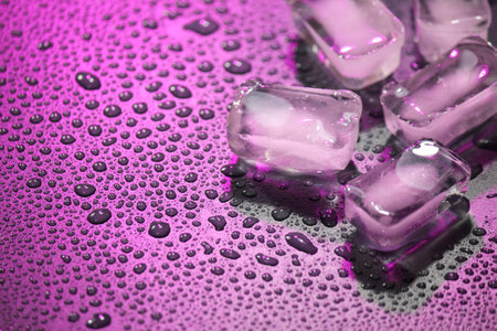 Melting transparent ice with drops of water on a dark background.の写真素材