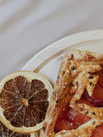 Homemade pie with jam, in the style of autumn comfort. A dried orange is laid out around the pie.の写真素材