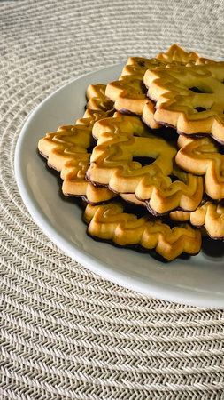 Golden, patterned butter cookies on a textured surface