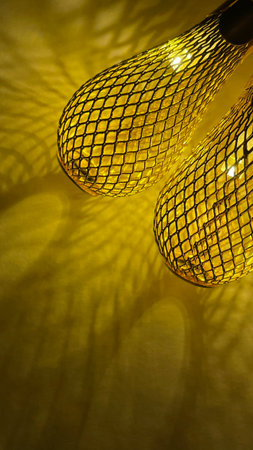 Warm golden string lights with a beautiful metallic mesh texture creating a cozy and festive atmosphereの写真素材