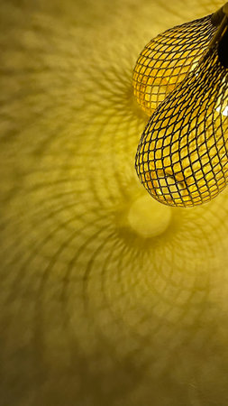 Warm golden string lights with a beautiful metallic mesh texture creating a cozy and festive atmosphereの写真素材