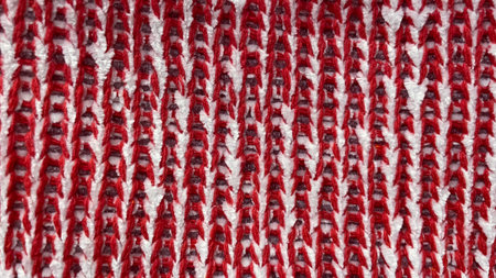 Abstract macro background of red and white knitted fabric with a distinct zigzag/wavy textureの写真素材