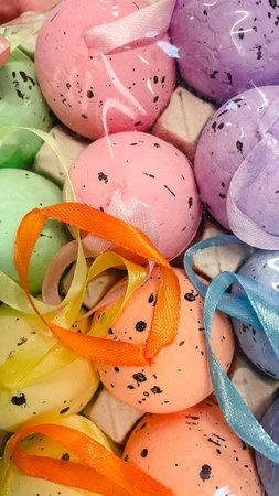 Close-up of colorful speckled Easter eggs with satin ribbons, vibrant festive holiday decorations.