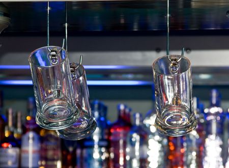 Beer mugs hanging in a bar close-upの写真素材