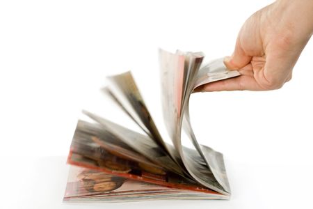 Hand which is thumbing magazine. Isolated on whiteの写真素材