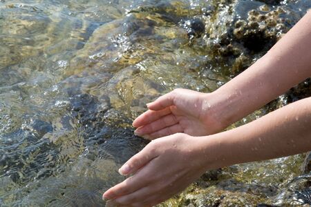 Hands with clean water in riverの写真素材