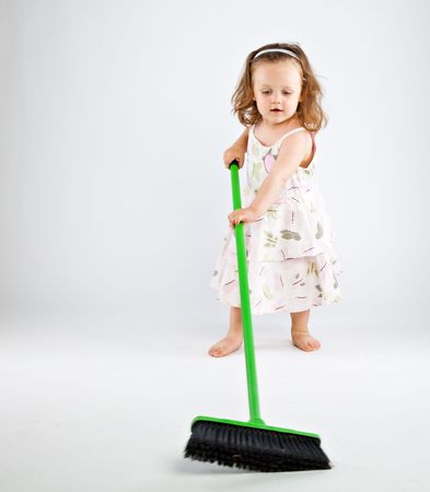 Little girl with mop on gray backgroundの写真素材