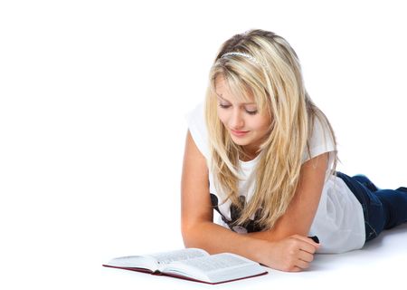 Girl laying on the floor and reading book. Isolated on white backgroundの写真素材
