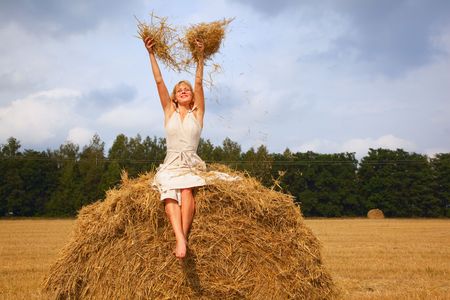 Young beautiful woman is sitting on a strawの写真素材