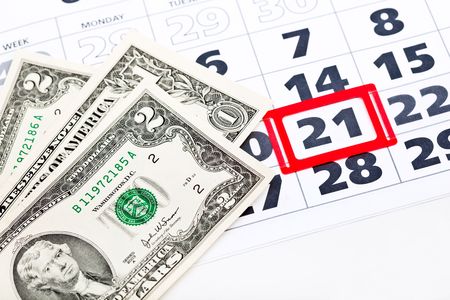 Dollar bills on calendar. Isolated on white backgroundの写真素材