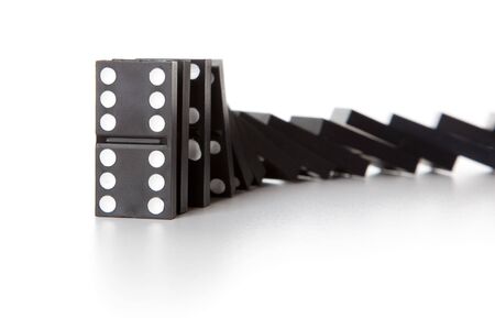 Stack of dominoes falling. Isolated on a white backgroundの写真素材