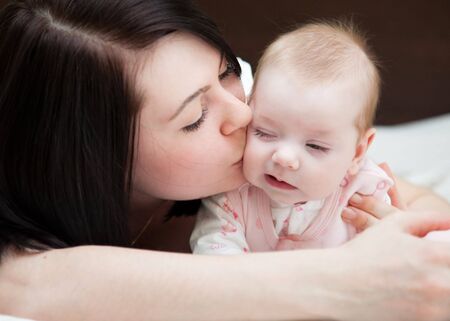 Adorable baby and mother in homeの写真素材