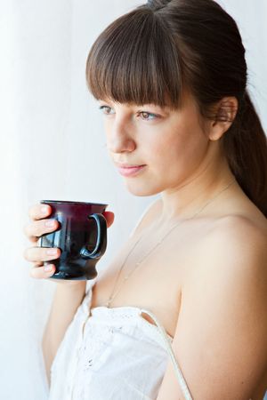 Young wonan near a window is dreanking coffeeの写真素材