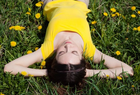 Young brunette woman in dandelionの写真素材