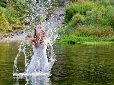 Young woman in white dress in a river