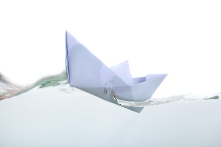 a paper boat in pure transparent water. isolated on a white backgroundの写真素材