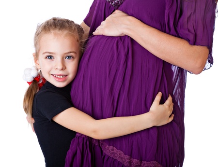 a smiling girl is listening to the abdomen of her mother. isolated on a white backgroundの写真素材