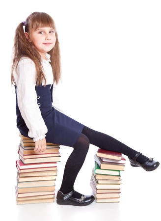 Schoolgirl is sitting on the booksの写真素材
