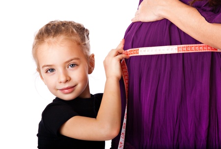 a cute girl measures the belly of her mother. isolated on a white backgroundの写真素材
