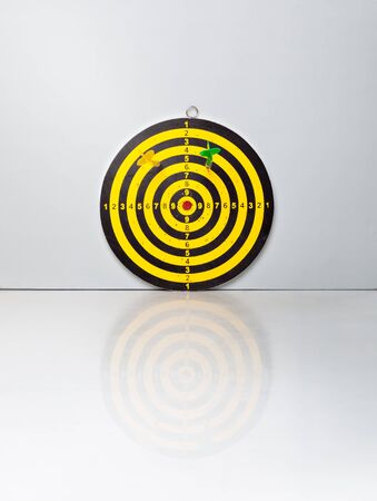 A target with a darts on on a grey background