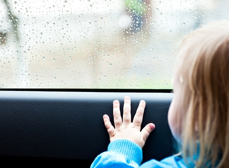 Little  girl in a car is looking out the windowの写真素材