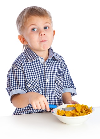 A boy is eating cereal from a bowl. Isolated on a white backgroundの写真素材
