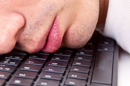 A tired man is sleeping on the keyboardの写真素材