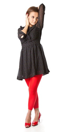 Portrait of teen girl. The girl is wearing black dress and red tights. Isolated on white backgroundの写真素材