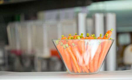 A bowl of carrots is standing on the tableの写真素材