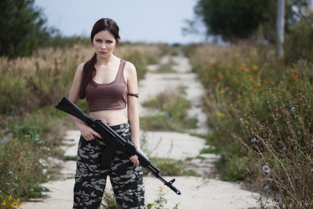 A beautiful military woman with an automatic rifle ak-74の写真素材