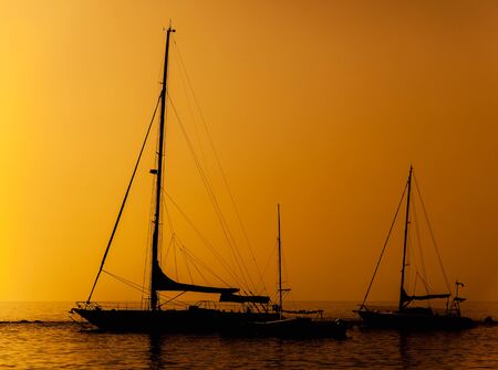 Silhouette of a ship in a sunset skyの写真素材
