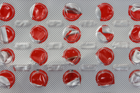 Blank capsule of medication blister packaging on red backgroundの写真素材