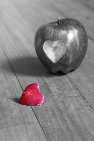 Red apple with a peeled heart shaped on wooden tableの写真素材