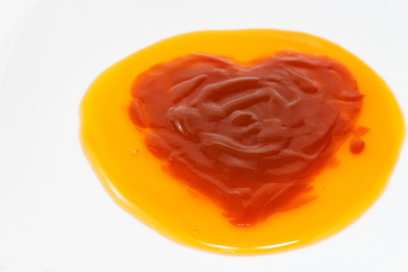 Tomato sauce love heart shaped on chili sauceの写真素材