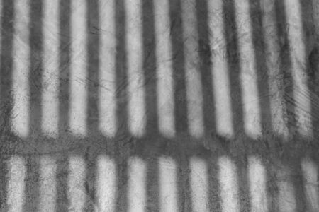The shadow of wooden fence on the concrete wallの写真素材