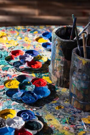 Artist's old palette and paintbrush on the table with many colorsの写真素材