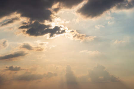 Sunshine hidden behind dark clouds in the sky before sunset