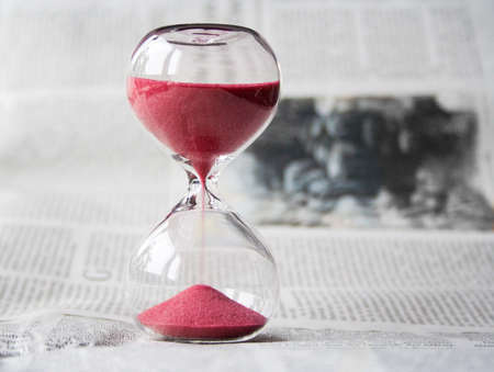 A hour glass on a table blur background