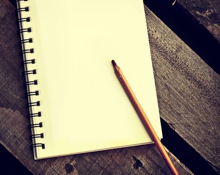 papers in a copybook with pen on wooden tableの写真素材