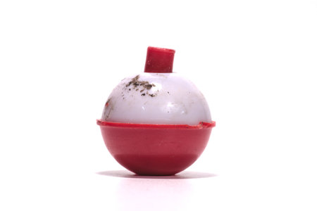 Close up of a red plastic fishing float isolated on white background.