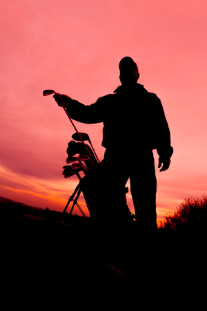 Golfer Silhouetted in Sunsetの写真素材